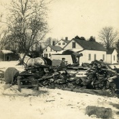 Unidentified men loading winter wood onto a wood pile at Rushmore Farms