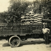 Leon A. Rushmore, Sr., on top of a loaded market truck, unidentified man [possibly Halstead Rushmore] leaning on truck, at Rushmore Farms